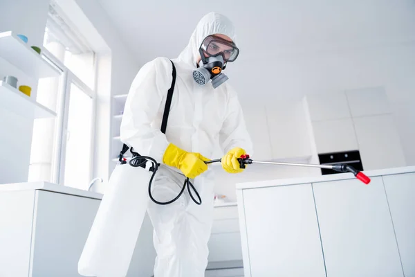 Low angle view photo of focused guy worker hold sprayer latex gloves gas glasses hands spray steam decontaminate ncov epidemic spreading in house kitchen indoors — Stock Photo, Image