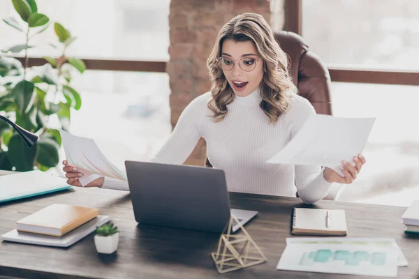 Portrait of her she nice attractive cheerful glad amazed wavy-haired girl financier analyzing income profit salary money in modern loft brick industrial interior style work place station