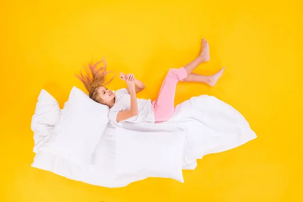 Top view above high angle flat lay flatlay lie concept of her she nice cheerful focused girl lying on blanket using cell chatting isolated bright vivid shine vibrant yellow color background