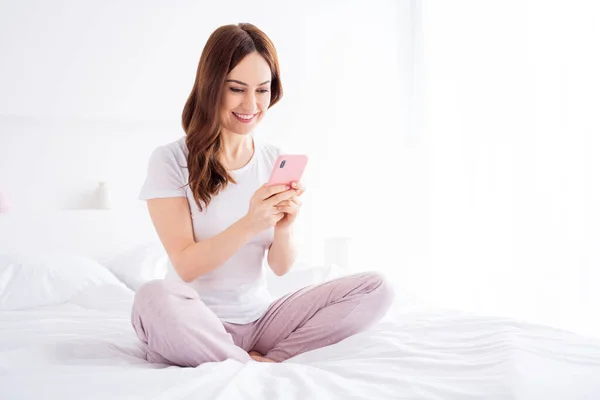 Retrato de ella ella agradable atractivo bonito muy centrado alegre pelirroja chica sentada en la cama usando dispositivo de aplicación 5g en el moderno apartamento de la casa de la habitación de estilo interior de luz blanca — Foto de Stock