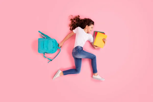 Top view above high angle flat lay flatlay lie concept portrait of nice beautiful cheerful small little wavy-haired girl carrying bag running lesson isolated over pink pastel color background — Stock Photo, Image