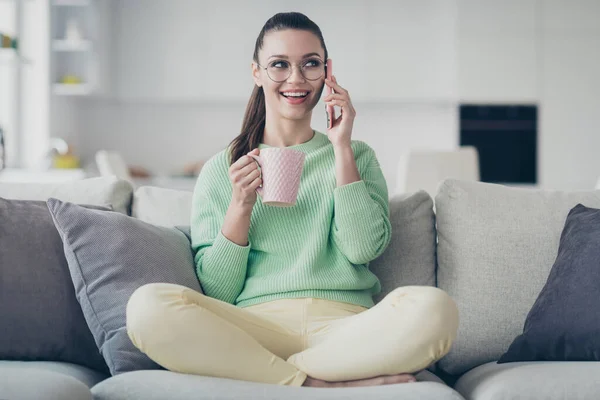 Porträtt av henne hon trevlig attraktiv vacker ganska söt glad flicka sitter på divan ringer till vän dricka kakao tillbringar ledig tid på ljus vit interiör rum studio platt inomhus — Stockfoto