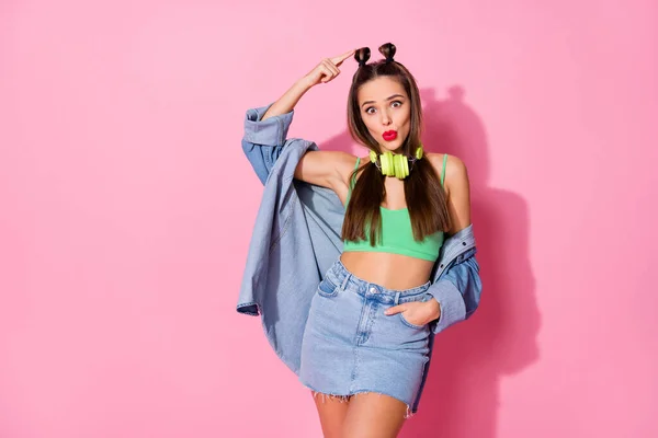 Photo de millennial jolie dame tête de doigt direct montrant moderne coiffure cool deux petits pains porter veste en denim vert crop top jupe courte isolé couleur rose pastel fond — Photo