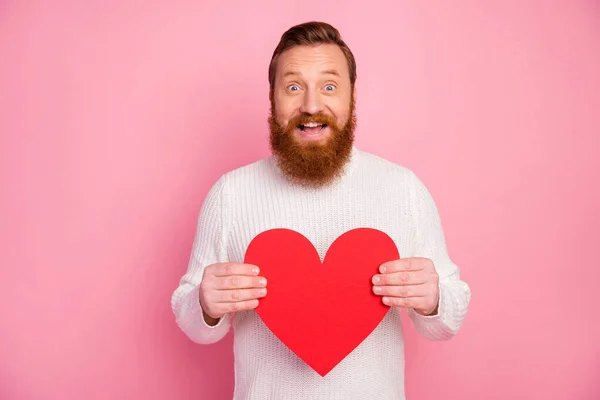 Retrato de chico contenido alegre celebrar rojo grande tarjeta de papel corazón que recibe el 14-febrero fecha de celebración desgaste acogedor jersey confort aislado sobre fondo de color pastel —  Fotos de Stock