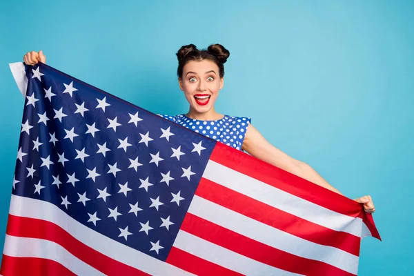 Фото красивой красивой дамы с открытым ртом, держащей большой американский флаг, отмечающий национальный традиционный праздник носить белые пунктирные блузки рубашку изолированный синий цвет фона — стоковое фото
