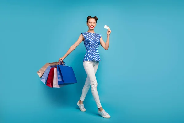 Teljes test profil fotó elég vicces hölgy séta utca hordoznak sok csomag műanyag hitelkártya függő vásárló viselni pontozott retro blúz fehér nadrág lábbeli elszigetelt kék színű háttér — Stock Fotó
