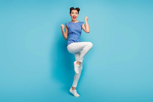 Foto de comprimento total de senhora louca bom humor celebrando férias de verão início levantar punhos desgaste blusa pontilhada calças brancas sapatos isolado azul cor de fundo — Fotografia de Stock