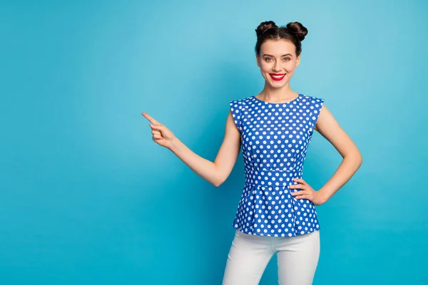 Photo of pretty lady sale manager directing finger empty space advising low shopping prices red lips wear dotted blouse shirt white pants isolated blue color background