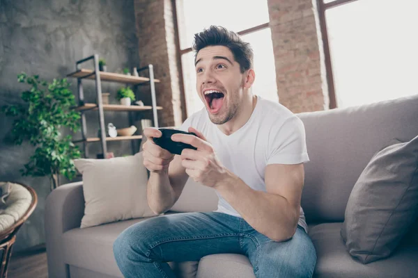 Portret van hem hij mooi aantrekkelijk blij gek verslaafd vrolijk vrolijk gespierd jongen spelen spel plezier vrije tijd in moderne industriële loft baksteen interieur stijl woonkamer — Stockfoto