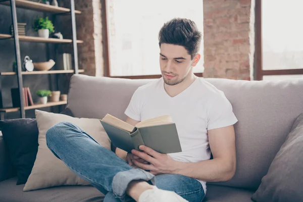 Portret van hem hij mooie aantrekkelijke gefocuste vreedzame slimme brunette kerel zittend op divan lezen van papier boek op moderne industriële loft baksteen interieur stijl woonkamer studio — Stockfoto