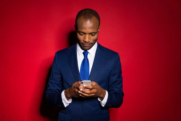 Portrait von seinem netten attraktiven fokussierten Kerl, der in den Händen hält, indem er Handy-Chat Unternehmens-App 5g Service-Lösung trägt, Smoking isoliert über rotem weinrotem Marsala-Hintergrund — Stockfoto