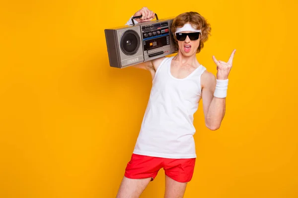 Portret van zijn hij mooie aantrekkelijke koele funky foxy gember guy dragen boombox tonen hoorn symbool zware metalen partij geïsoleerd over heldere levendige glans levendige gele kleur achtergrond — Stockfoto