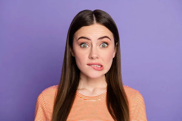 Foto close-up de atraente senhora aterrorizada mordendo lábios fez grande erro olhos cheios de medo se sentir culpado desgaste casual laranja listrado t-shirt isolado pastel cor roxa fundo — Fotografia de Stock