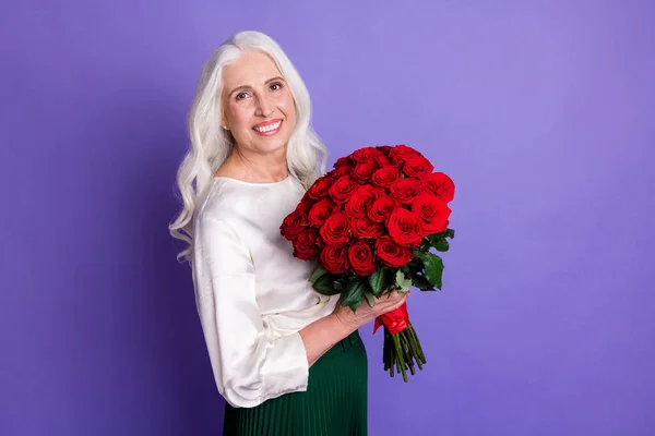 Γύρισε φωτογραφία του χαρούμενα ικανοποιημένη ηλικιωμένη γυναίκα κρατήσει μεγάλο μπουκέτο τριαντάφυλλα παίρνει τον σύζυγό της οικογένεια 8-Μάρτιος 14-Φεβρουάριος γιορτή φορούν καλά ρούχα εμφάνιση απομονώνονται πάνω βιολετί χρώμα φόντο — Φωτογραφία Αρχείου