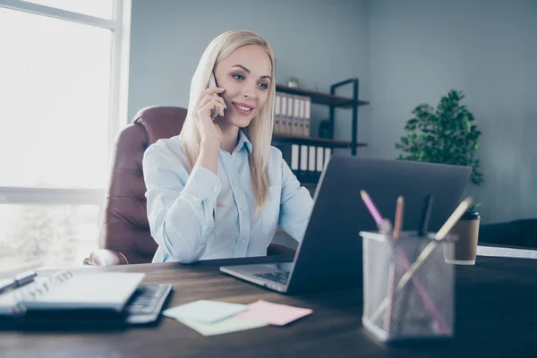 Foto de atractiva dama de negocios chateando colegas hablando teléfono leer informe corporativo portátil mesa de seguros agente usar camisa silla de estar moderno interior oficina interior interior — Foto de Stock