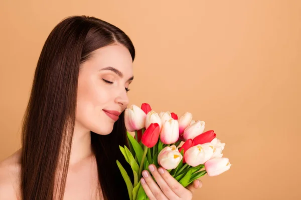 Profil sida närbild foto av charmig kvinna hålla blomma bukett tulpaner gåva 8-mars firande vår semester ges efter spa salong förfarande lukt doft njuta av isolerade beige färg bakgrund — Stockfoto