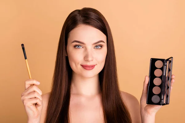 Close-up foto van aantrekkelijke meisje houden penseel palet oogschaduwen willen nieuwe ideale perfecte make-up voor prom geïsoleerd over beige kleur achtergrond — Stockfoto