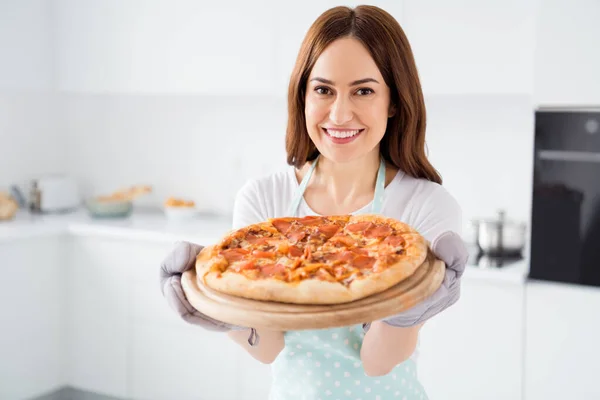 Close-up foto de bela dona de casa alegre desfrutar de hobby cozinhar receita familiar jantar pizza quente pronto refeição de quarentena forno usar luvas de avental de pé cozinha moderna em casa — Fotografia de Stock