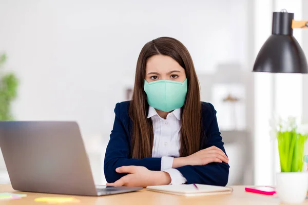 Foto van kleine student schoolmeisje student notebook tafel online les video oproep zitten bureau moe van sociale afstand met behulp van bescherming masker quarantaine studie woonkamer klaslokaal binnen — Stockfoto