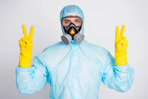 Retrato de trabajador médico hacer v-signo de desgaste blanco biohazard máscara de respiración uniforme aislado sobre fondo de color gris — Foto de Stock