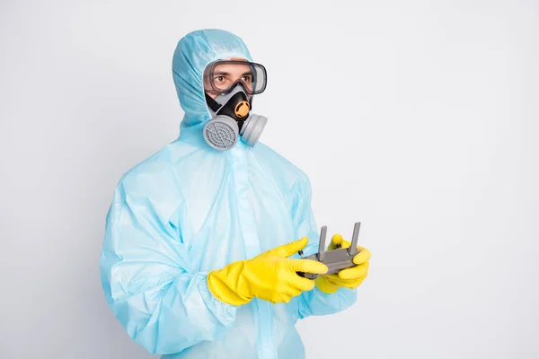 Photo of doctor man hold joystick control flying drone wear hazmat suit yellow latex rubber gloves goggles maska oddechowa izolowana na szarym tle koloru — Zdjęcie stockowe