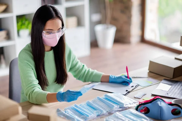 Foto van Chinese drukke dame familiebedrijf organiseren verpakking gezicht griep medische maskers wereldwijde verspreiding schrijf order details voor te bereiden sets voor levering thuis kantoor quarantaine binnen — Stockfoto