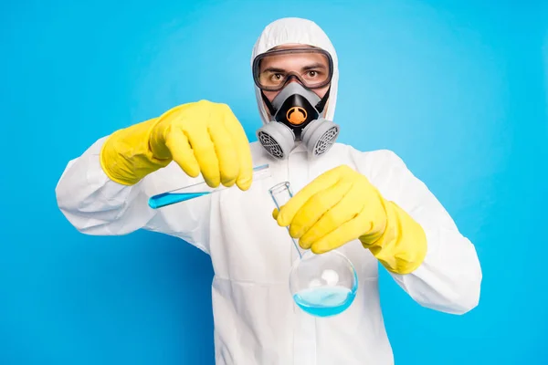 Portret van slimme wetenschapper pour ncov vaccinatiesonde dragen witte pak hazmat gele latex handschoenen bril ademhaling masker geïsoleerd over blauwe kleur achtergrond — Stockfoto