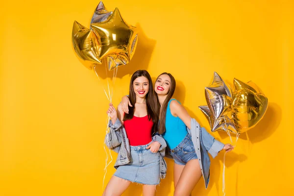 Portret van mooie aantrekkelijke mooie mooie charmante prachtige vrolijke vrolijke blij meisjes houden in handen helium ballen feestelijk geïsoleerd op heldere levendige glans levendige gele kleur achtergrond — Stockfoto