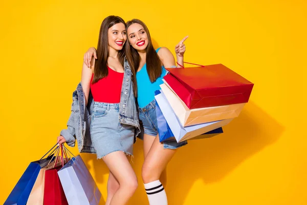 Porträt von schönen attraktiven schönen hübsch charmant atemberaubende fröhliche Mädchen tragen neue Dinge Kleidung zeigt Wahl isoliert auf hellen lebendigen Glanz lebendigen gelben Farbhintergrund — Stockfoto