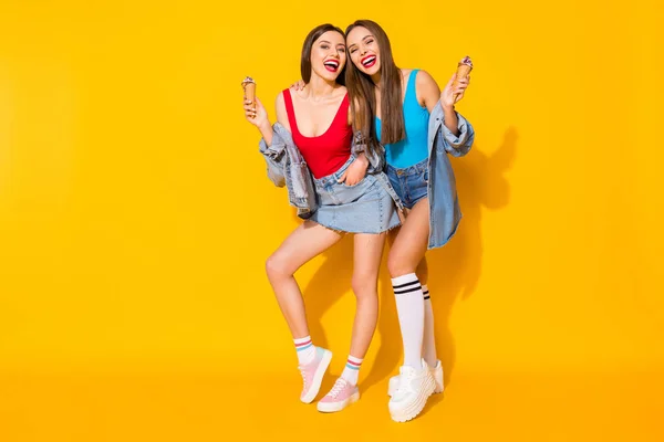 Full length body size view of her she nice-looking attractive glamorous cheerful cheery girls eating icecream having fun isolated on bright vivid shine vibrant yellow color background — Stock Photo, Image