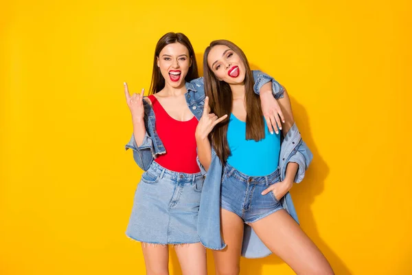 Retrato de louco engraçado animado meninas desfrutar de rock and roll pank fim de semana show chifres símbolo desgaste jeans tank-top isolado sobre brilhante brilho cor fundo — Fotografia de Stock