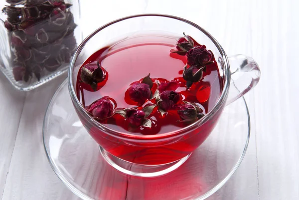 Hibiscus çiçeği çayı ve tatlı bir gül. Çiçek çaylı cam bardak.