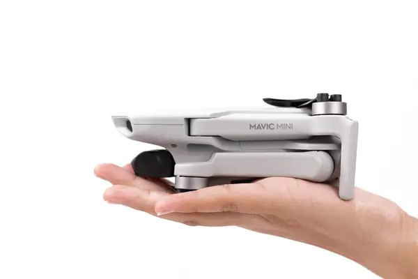 SKUDAI, JOHOR-MAY 6 2020: Mavic Mini DJI beyaz arkaplanda bir çocuğun elinde