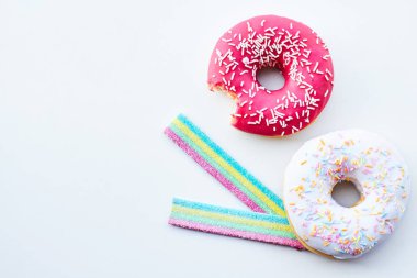 Pembe çörek ve jöle şekerler izole beyaz arka plan üzerinde ısırıldı. Kopya alanı.