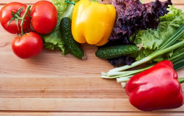 Taze sebze çeşitli ahşap masa üzerinde. Yemek düzeni. Kopya alanı