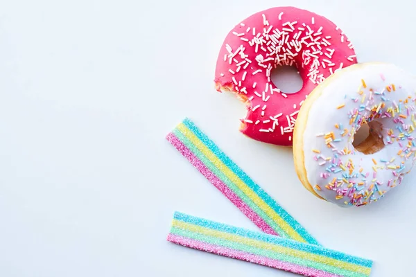 Pembe çörek ve jöle şekerler izole beyaz arka plan üzerinde ısırıldı. Kopya alanı.