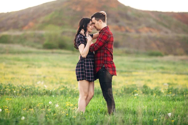 Beautiful couple man and woman stand embraced at the green bloom — Stock Photo, Image