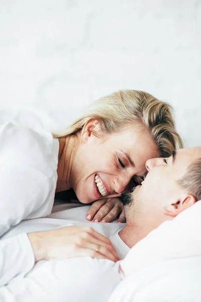 Genç çift rahatlatıcı, kucaklamak ve yatakta yatıyordu eğlenceli.
