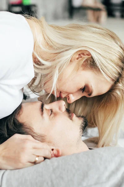 Sarışın kadın iyi ve oturma rahatlatıcı erkeğini ile yatak.