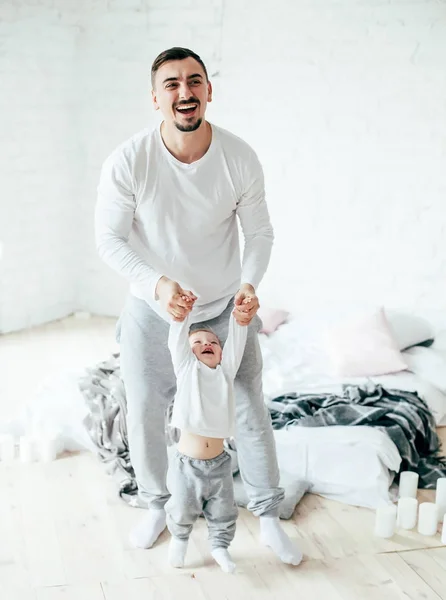 Genç Baba oynayan ve ilk adımlar için bir yürüyüş yaparken oğlu öğretim