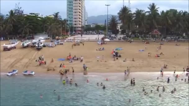 Visitatori e viaggiatori nuotano sulla spiaggia di una città costiera in Asia — Video Stock