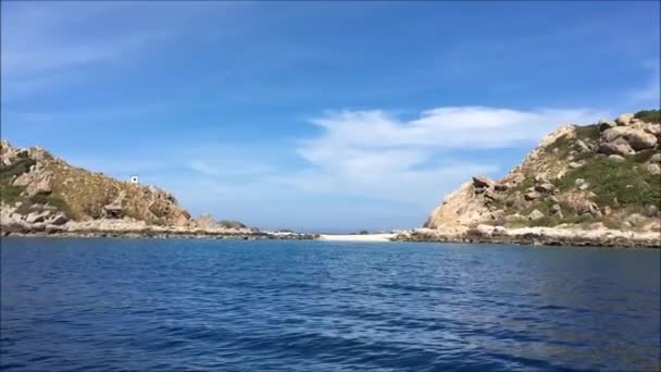 Isla en el mar en un día soleado con cielo azul y aguas tranquilas — Vídeos de Stock