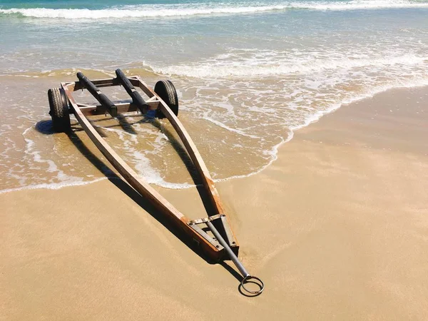 Deniz dalga köpüğü ile sahilde el arabası — Stok fotoğraf
