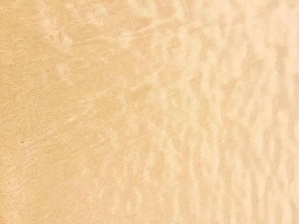 Текстура на желтом пляже под солнцем — стоковое фото