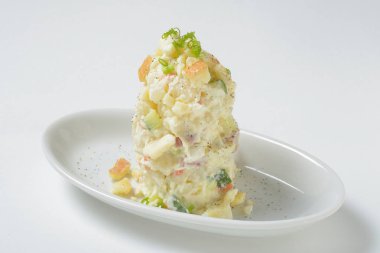 Beyaz tabakta kremalı patates ile karışık meyve