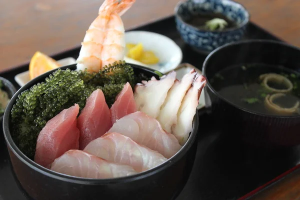 Сашими из тунца, креветок и кальмаров на черном блюде — стоковое фото