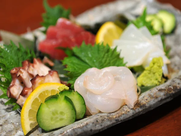 Свежие сашими из рыбы фугу с огурцом, лимоном и васаби — стоковое фото