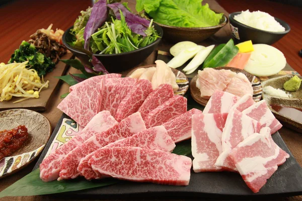 Vers gesneden rundvlees met groenten op tabellen in de keuken — Stockfoto