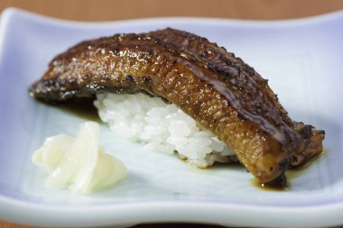 Beyaz tabak üzerinde kızarmış yılan balığı ile düz pirinç