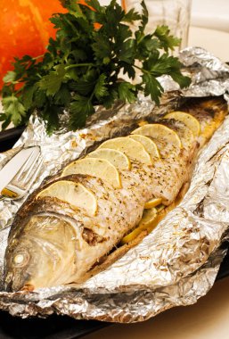 Fried sazan ile limon, limon ve folyo üzerinde otlar